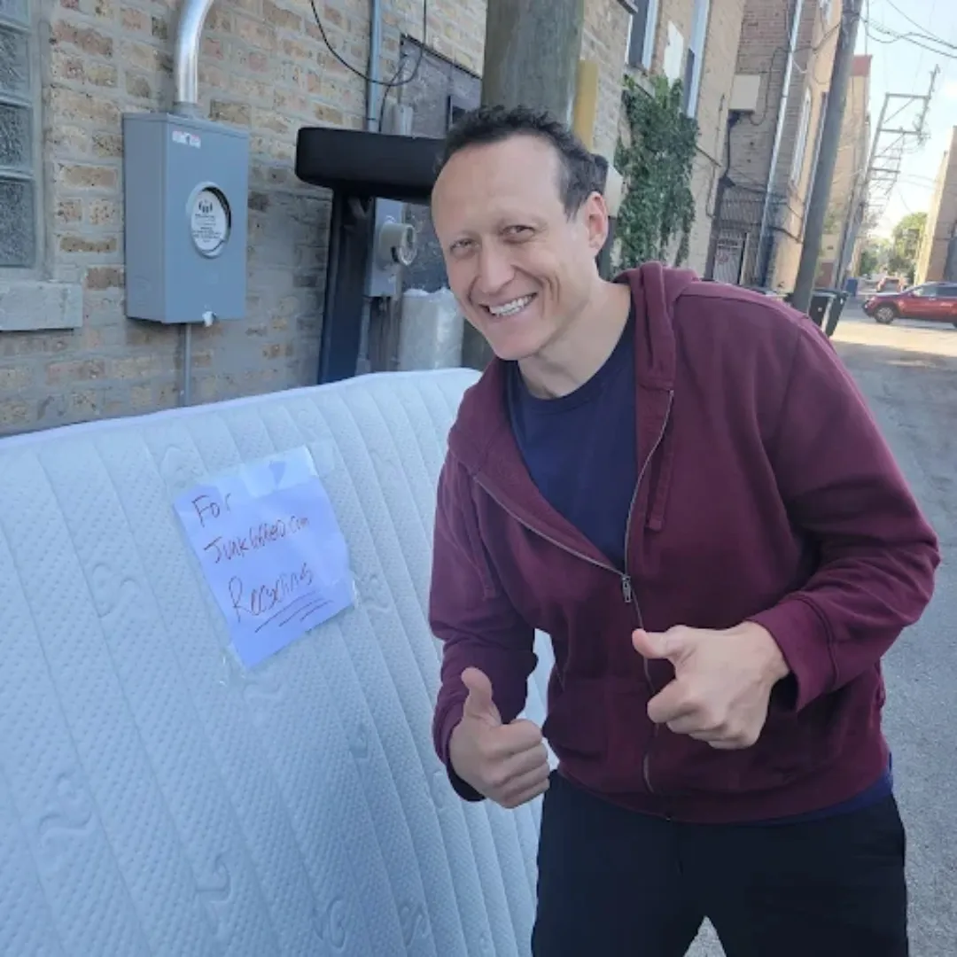 Junk Robbers team member beside a mattress