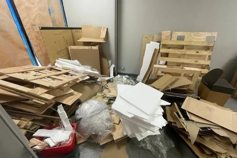 Wooden pallets, cardboard, and packing debris awaiting removal
